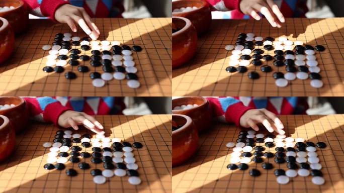 中国小孩在窗边下棋围棋手部特写