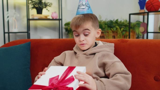 快乐的童男童女拿着带丝带的生日礼盒，在家里开庆祝会，打开礼物