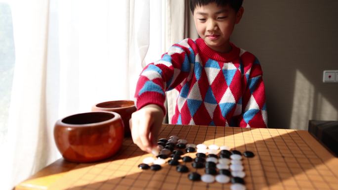 中国小孩在窗边下棋围棋