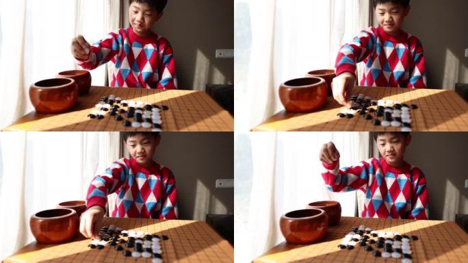 中国小孩在窗边下棋围棋