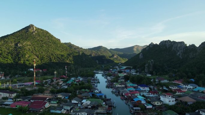 无人机飞向风景如画的风景，而Bang Pu渔村被山脉的阴影所覆盖，泰国，Prachuap Khiri