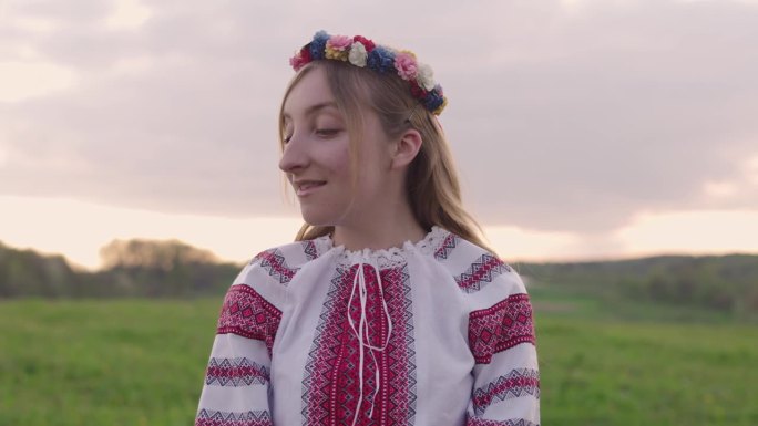 年轻美丽的乌克兰妇女的肖像在vyshyvanka -乌克兰民族服装在乡村户外日落。与乌克兰站在一起