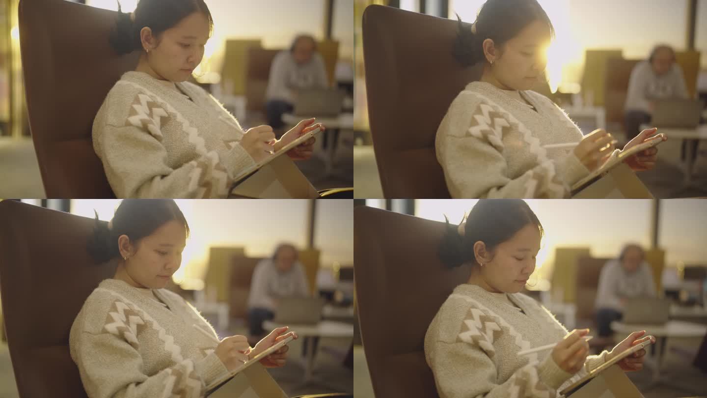亚洲女性拿着平板电脑在候诊室或大厅休息。
