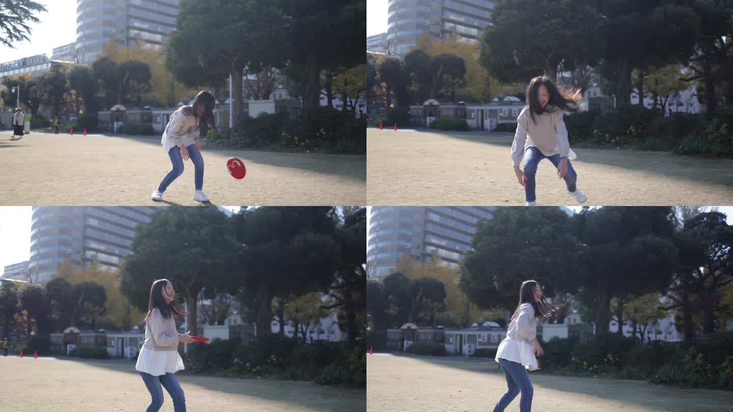 十几岁的女孩在公园里捕捉和投掷飞盘-慢动作