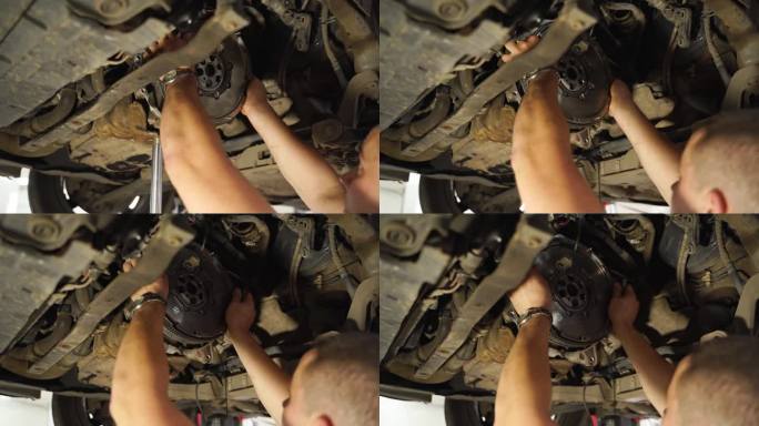 汽车修理工正在更换汽车离合器。用手拆卸旧的离合器，安装新的离合器盘、阀盖、分离轴承。起重汽车维修，车