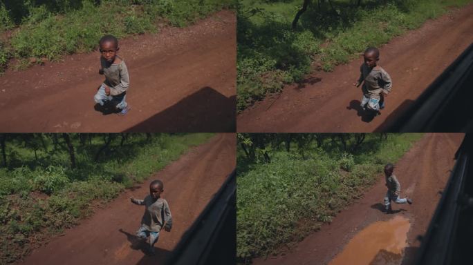 慢镜头非洲男孩在卡车旁奔跑，非洲女孩微笑着挥手。快乐的男孩们在他们的村庄里跟随车辆。