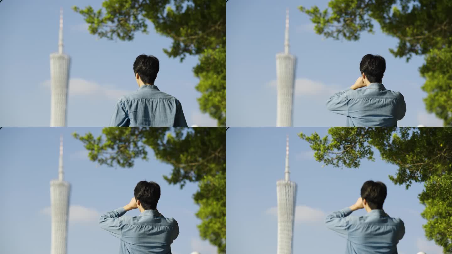 男人对着广州塔拍照