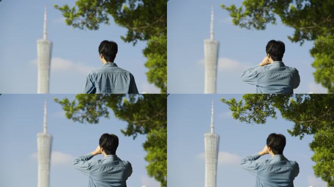 男人对着广州塔拍照