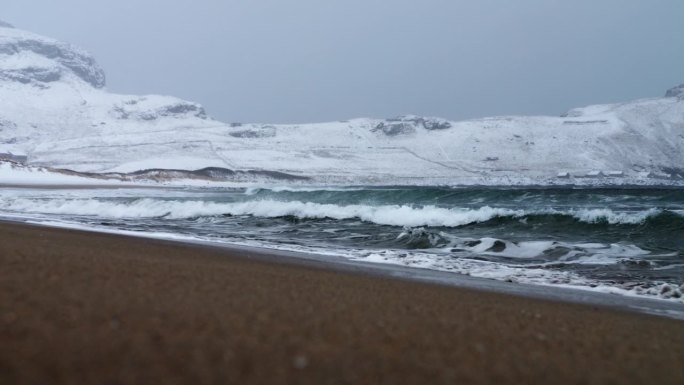 挪威埃尔维克海滩上，寒冷的冬季波涛汹涌，大雪纷飞，狂风呼啸