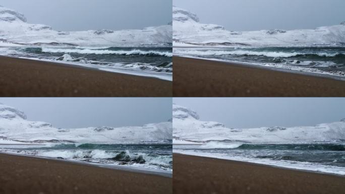 挪威埃尔维克海滩上，寒冷的冬季波涛汹涌，大雪纷飞，狂风呼啸