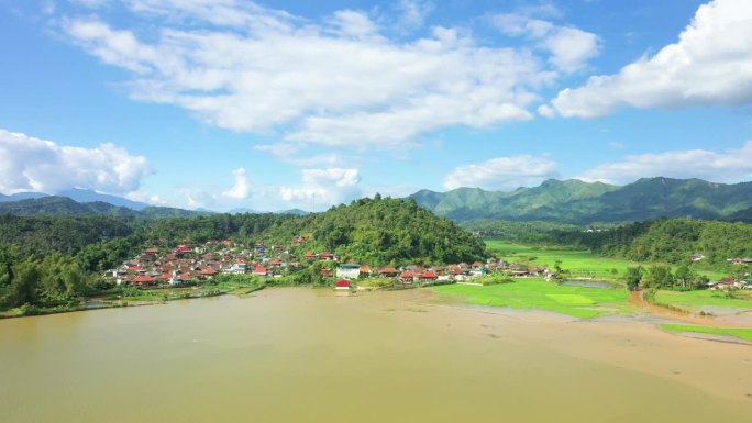 亚洲，越南，东京，奠边府，一个阳光明媚的夏日，一个乡村湖边的小村庄，被淹没的稻田依偎在群山之间。