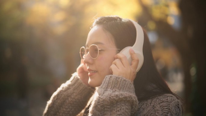 一个年轻女子戴上白色耳机的瞬间