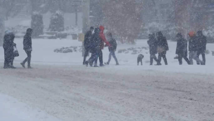 暴风雪中城市街道上车辆和行人的交通状况