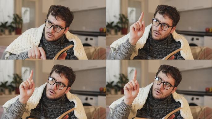 戴眼镜的男人在享受一本书，他的惊讶用一个举起的手指表示