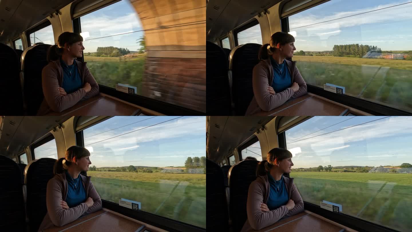 一位微笑的女旅客坐火车穿越风景优美的英国乡村