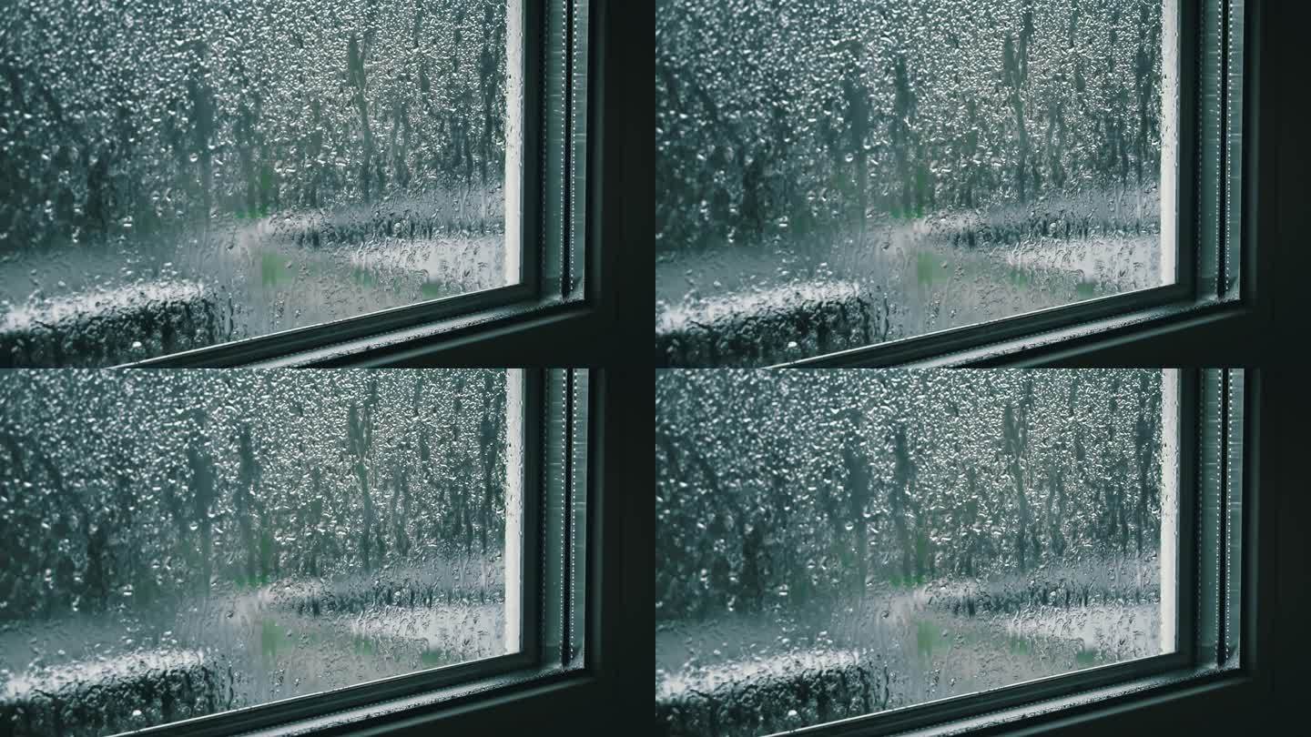阴天里雨滴顺着窗玻璃流下来