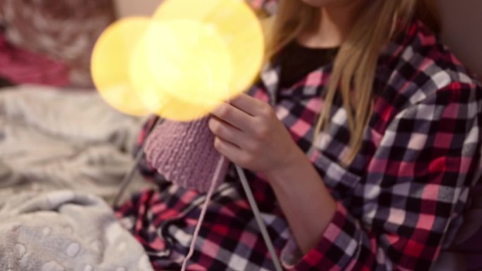 圣诞期间，一位年轻女子在家里放松地织毛衣。