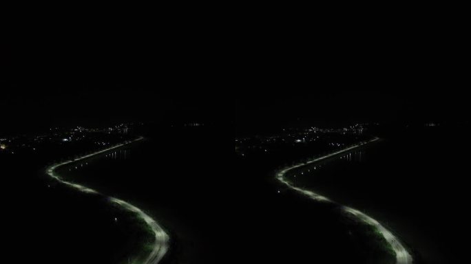 夜间无人街道的垂直无人机画面。印度尼西亚哥伦塔洛林波托湖边缘的一排路灯的垂直视频