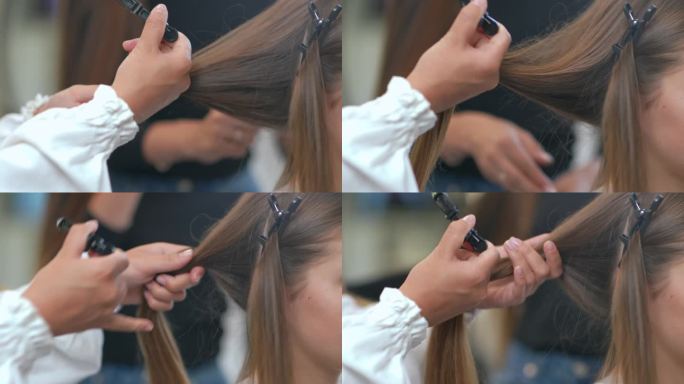 一位女理发师手里拿着客户的一缕头发，手里拿着发夹，旋转着头发。特写镜头。缓慢的运动。