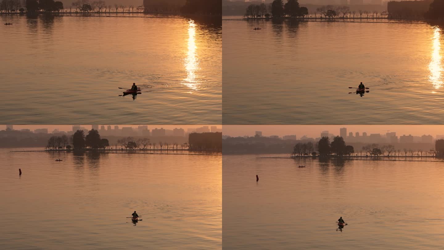 在东湖的夕阳下划船的游客