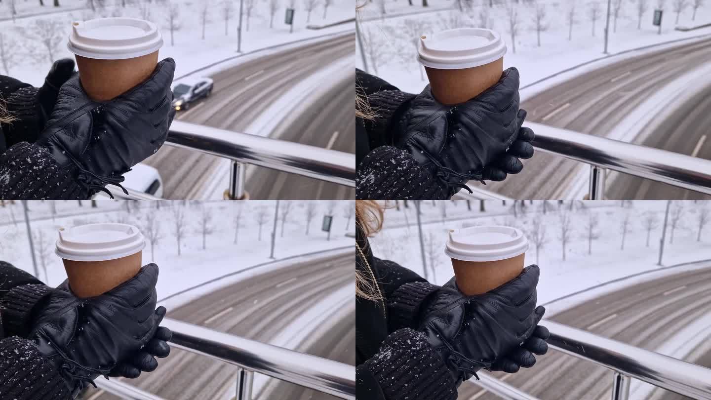 双手戴着手套，拿着一次性纸杯咖啡，冬天