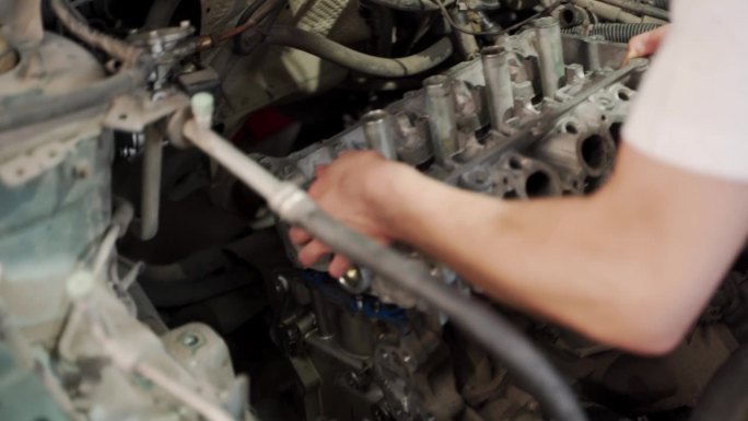 汽车修理工在车库用环形压缩机将活塞安装到发动机缸体中，车间指导技师改造汽车维修更换发动机零件DIY大
