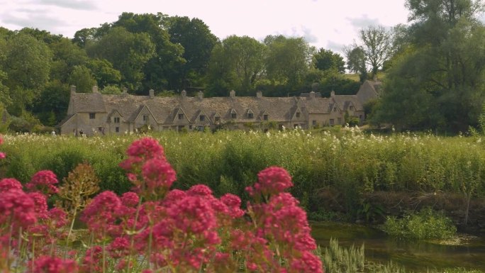 田园诗般的石头房子在英国乡村郁郁葱葱的绿色植物中隐约可见