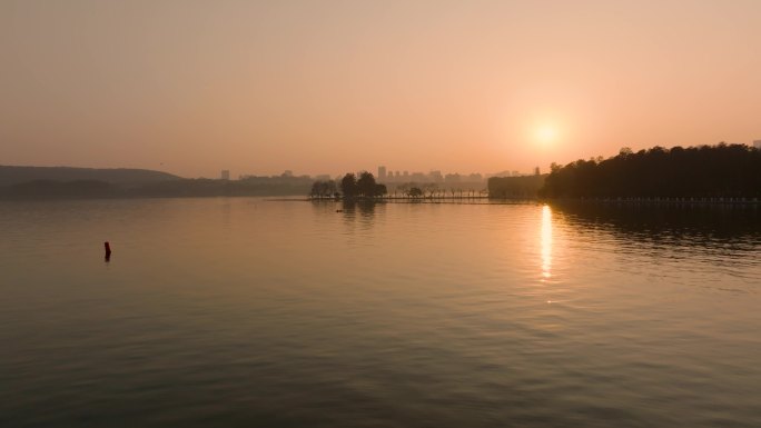 在东湖的夕阳下划船的游客
