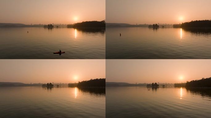 在东湖的夕阳下划船的游客