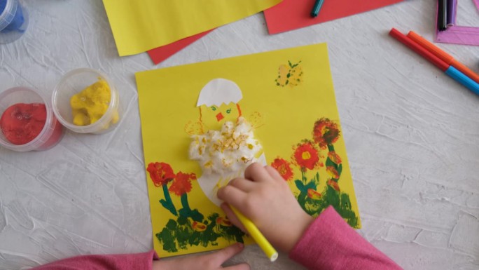 孩子用五颜六色的纸制作复活节彩蛋和鲜花卡片。