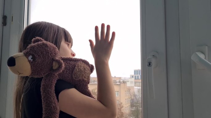 少女站在窗边，用手按住窗，若有所思，还是想出去
