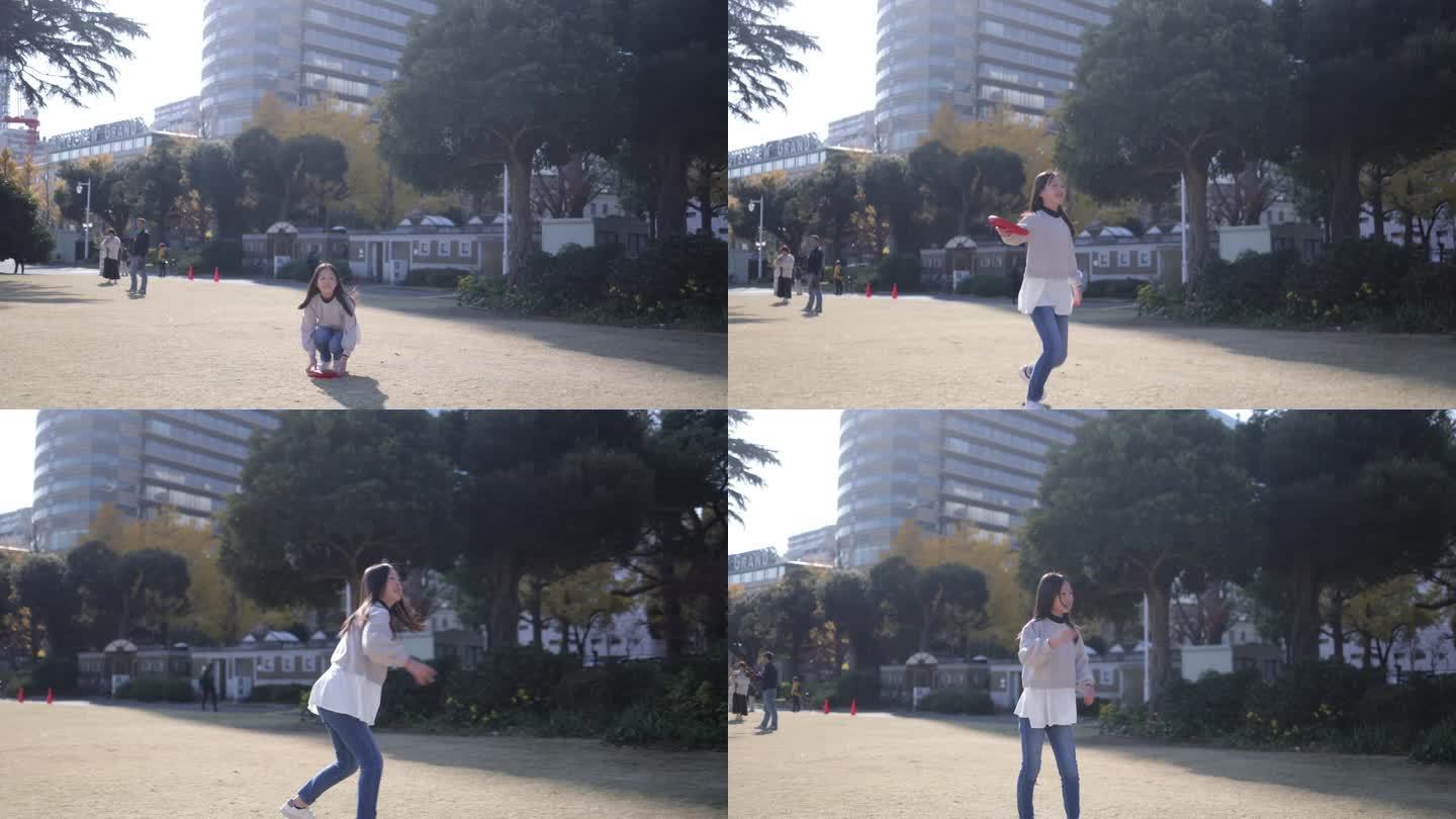 十几岁的女孩在公园里捕捉和投掷飞盘-慢动作