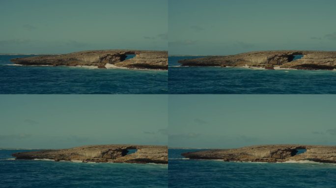 来自太平洋的深蓝色海浪撞击着这个岩石半岛，在夏威夷檀香山东角有一座天然石桥