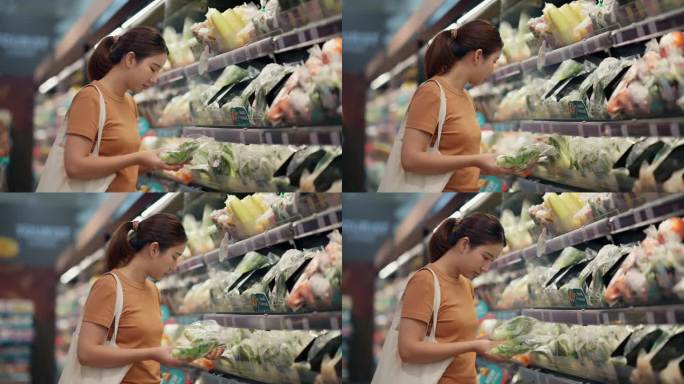 一位亚洲妇女在超市挑选蔬菜
