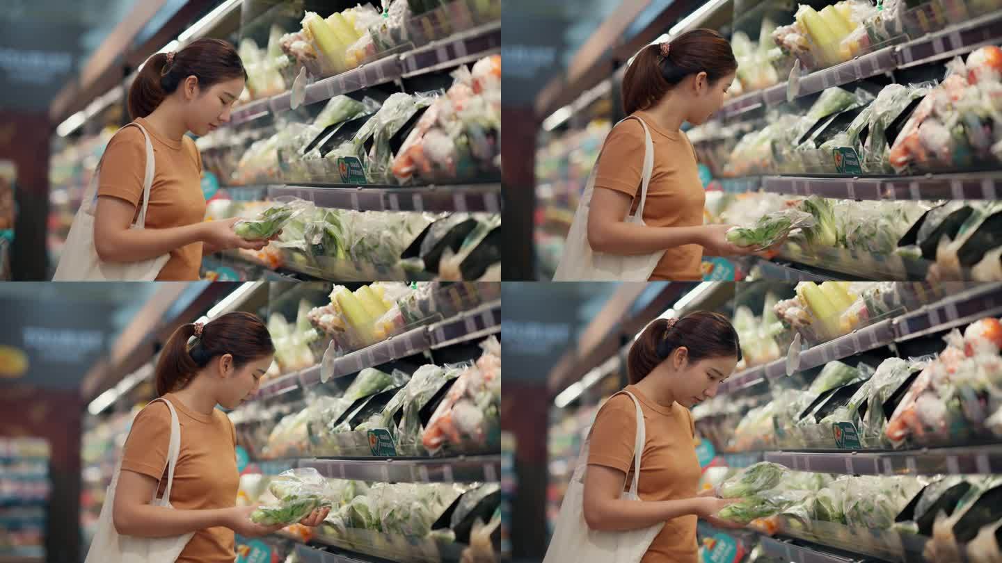 一位亚洲妇女在超市挑选蔬菜