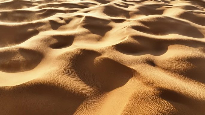在突尼斯4K航拍镜头中，无人机俯视着撒哈拉沙漠，随着风吹过山丘和沙丘的沙子旋转