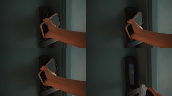 一个女人用智能手机触摸打开酒店房门的特写镜头。