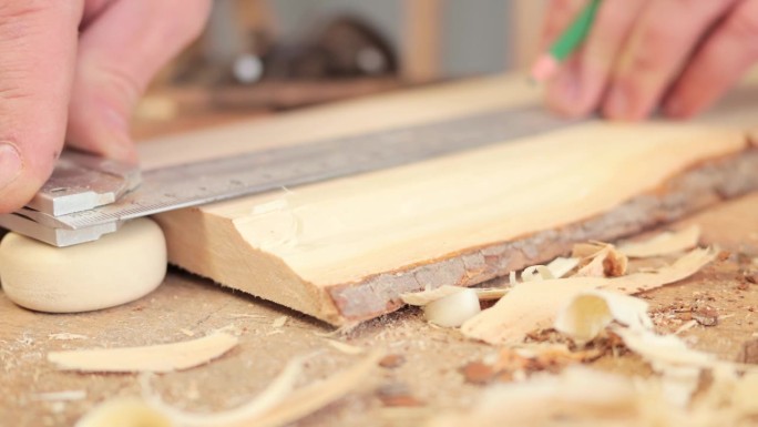 设计木工业务。木工的热情显而易见。手工木制品的奇迹。木匠的精湛手艺。在木工车间用刨子进行测量的面目全