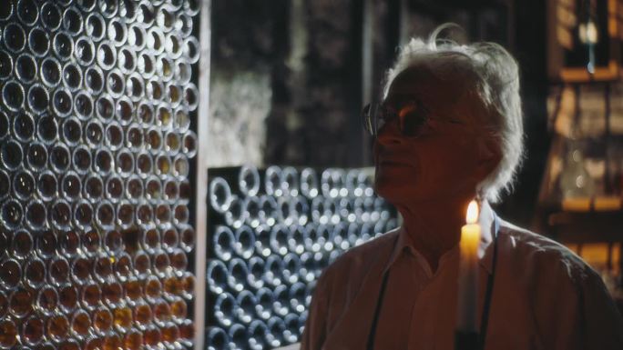 SLO MO葡萄酒遗产:在瓶装珍宝中沉思的酒商肖像，蜡烛，烛光，酿酒厂，葡萄酒，酒窖