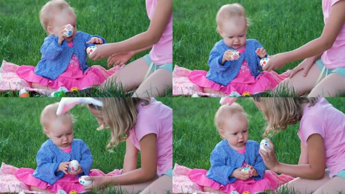 女孩带着小妹妹在草地上敲鸡蛋