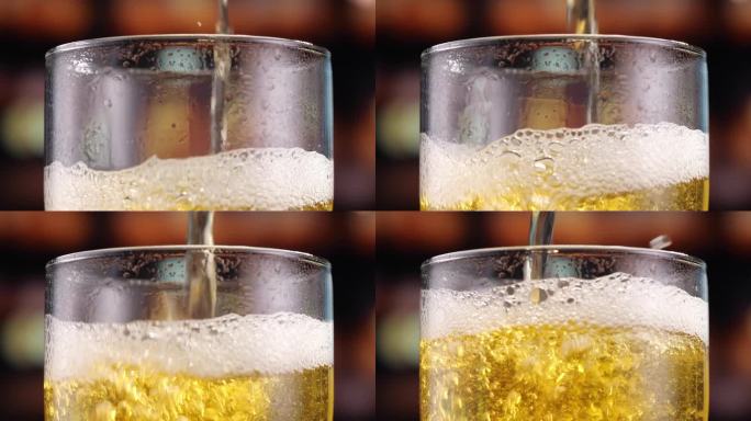 啤酒倒进玻璃杯，形成冒泡的气泡和泡沫的头部。细节拍摄，微距拍摄。啤酒抓住了十月庆典的精神。酒精饮料