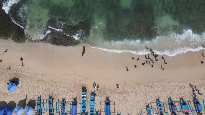 空中无人机拍摄的假期在印尼的古农海滩，有大海、船和人。