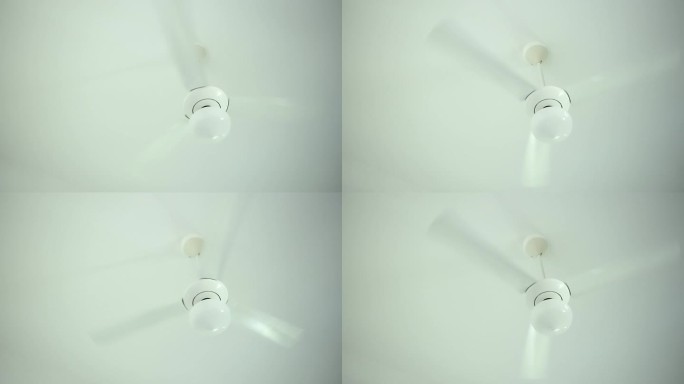 近距离白色吊扇，有3个叶片和灯，快速旋转，冷却房间里的空气。闷热的夏天，家里没有空调