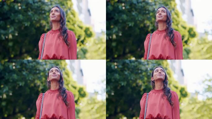 和一个印度女人在公园里，站在夏天的新鲜空气里，思考，未来和灵感。有远见、有想法、有幻想的年轻人在一个