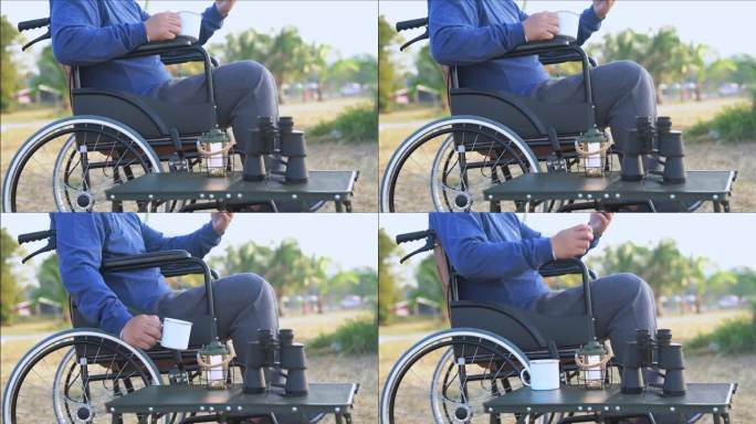 一个人坐在轮椅上，拿着智能手机，看着第一个金色的日出。