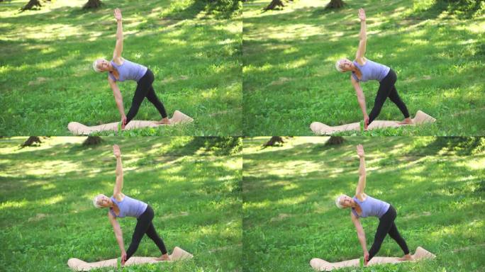 中年妇女在户外做伸展三角体式瑜伽。