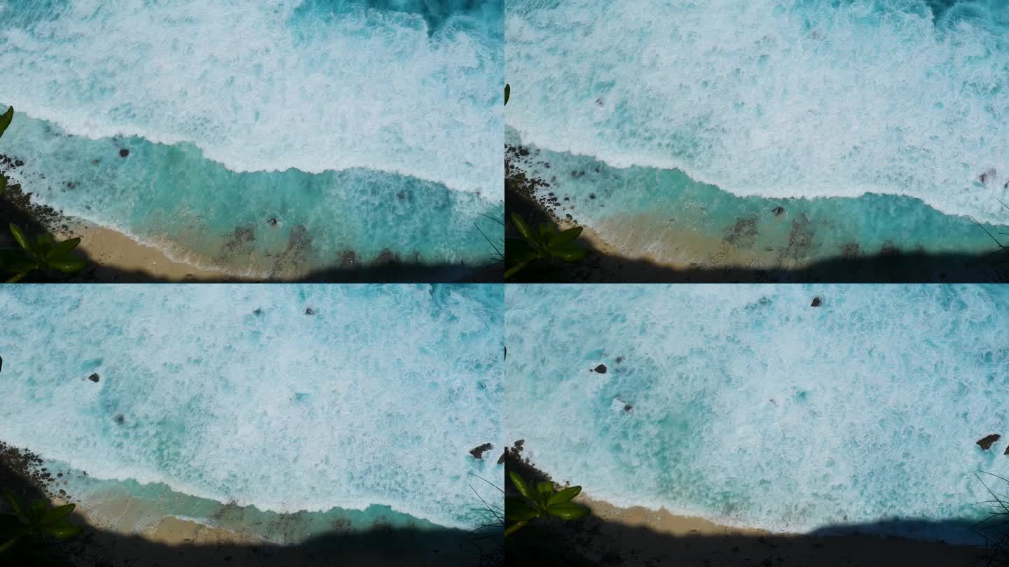蓝绿色的海洋海水白色的波浪溅深蓝色的大海。鸟瞰怪物波浪飞溅在岩石上。热带海滩在夏季海边户外。大洋岛风