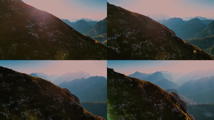 空中无人机拍摄的摩托车移动在巨大的山与雄伟的雾覆盖范围的背景在日落期间