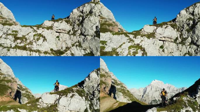 在晴朗的日子里，骑自行车的人坐在巨大的岩石悬崖上，面对晴朗的蓝天