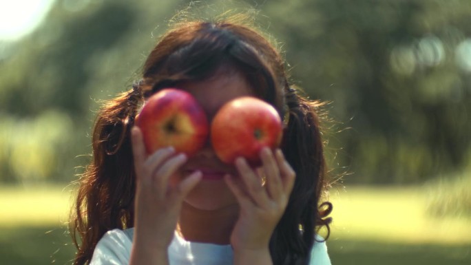 花园里的红苹果快乐女孩手举着苹果